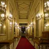 L�ambiente, illuminato da candelabri a parete, � scandito da panche e divanetti in tessuto...